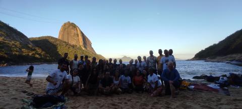 Foto dos participantes do evento, numa praia