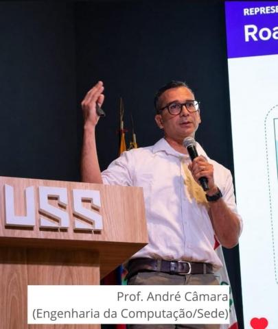 Prof Andre Camara discursa ao lado de púlpito